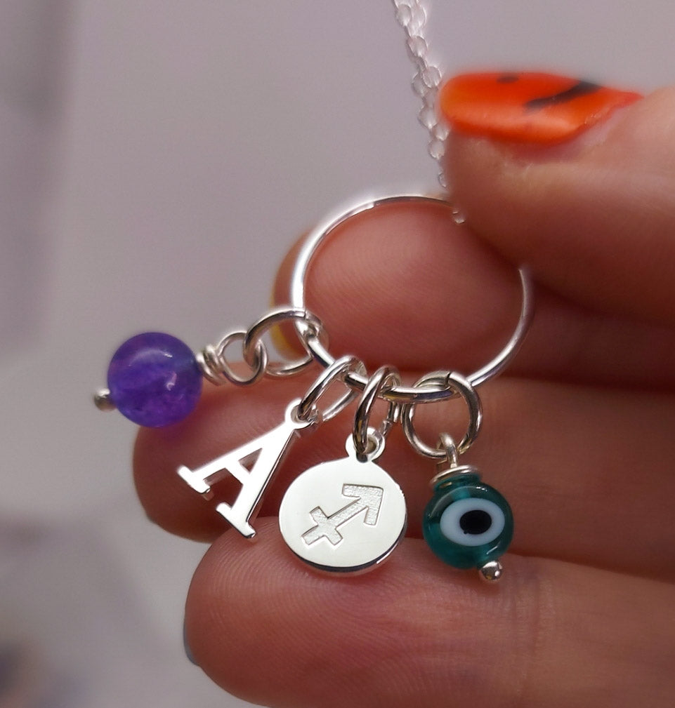 Collar inicial, signo, piedra y ojo